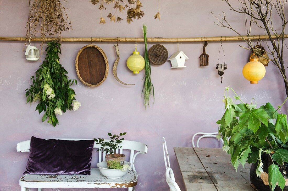 Deko hängt an lilafarbener Wand auf mediterraner Loggia