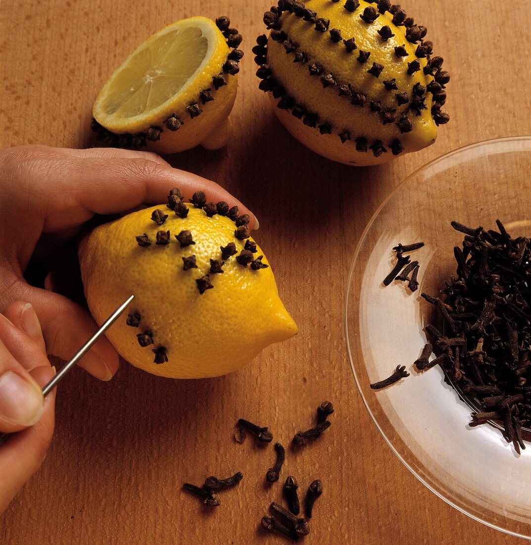 Making a lemon pomander with cloves