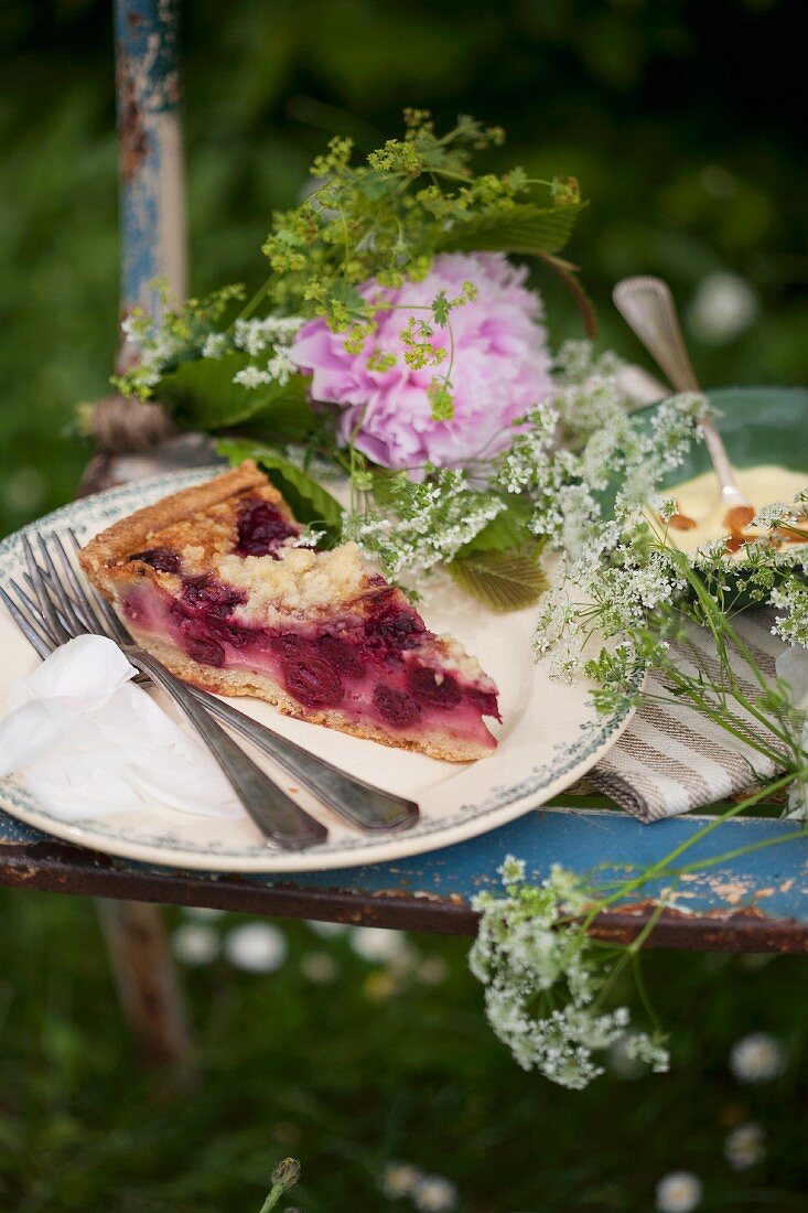 Gartenpicknick auf einem Stuhl mit Kuchen, Pudding und Blumen