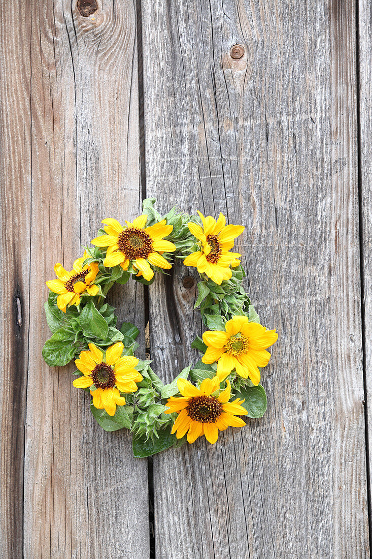 Kranz aus Sonnenblumen auf Holzuntergrund