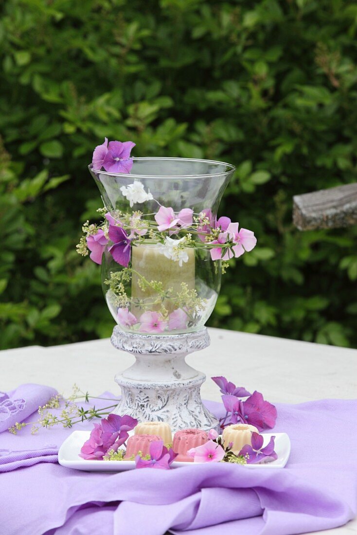Romantic candle lantern decorated with purple hydrangea and phlox flowers