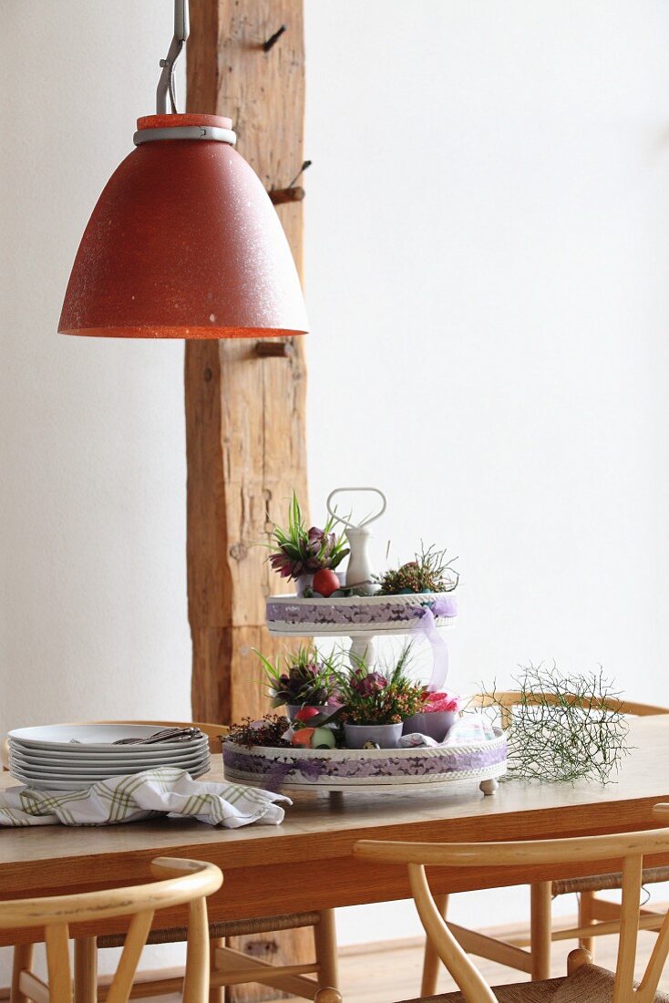 Festliche Etagere mit österlicher Blumendekoration auf Holztisch