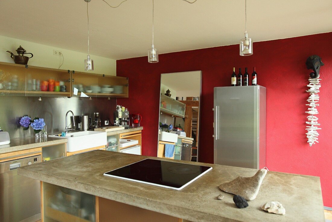 Küche mit Kücheninsel und roter Wand