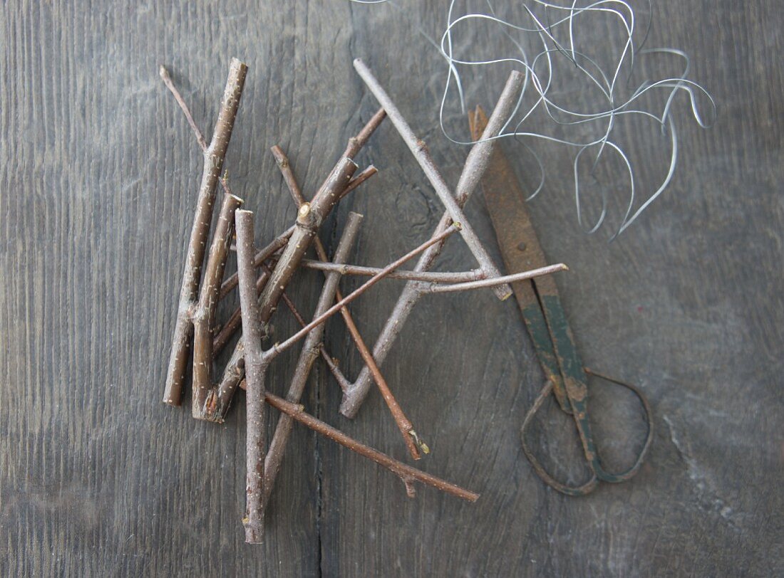 Twigs, vintage scissors and wire on rustic wooden surface
