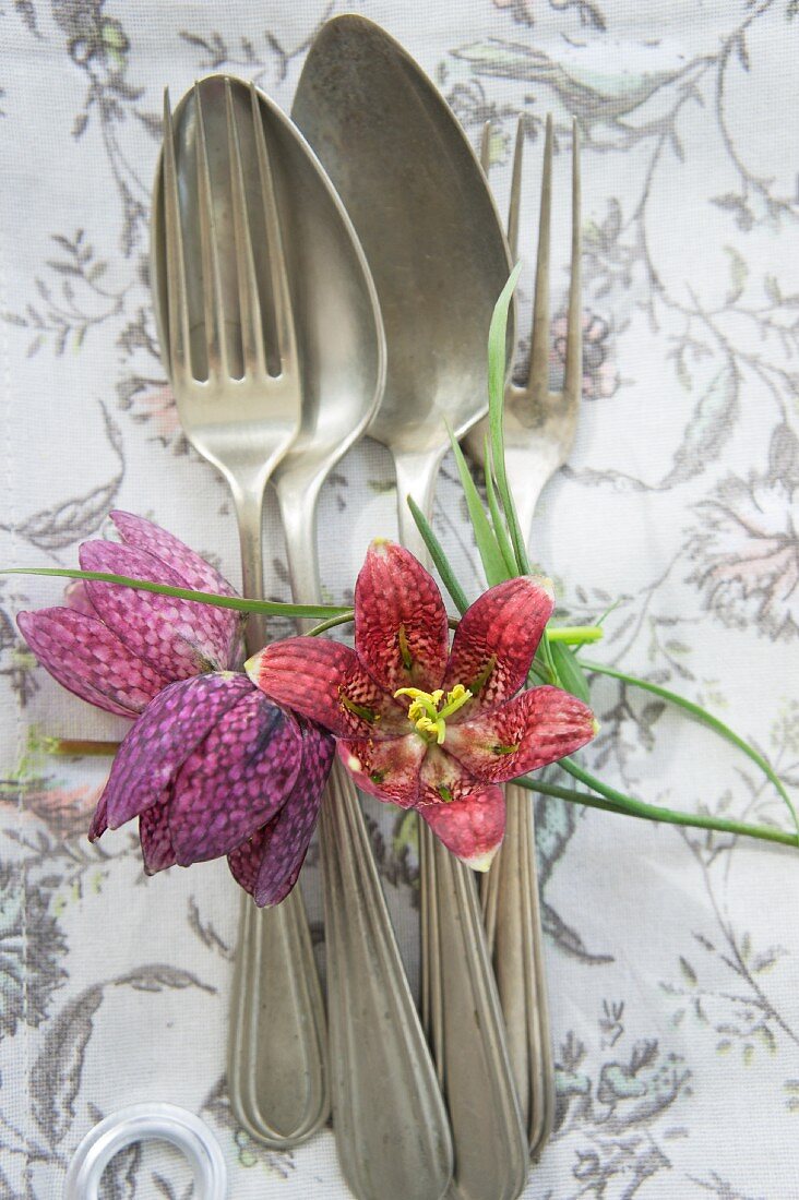 Vintage silver cutlery and flowers on linen napkin