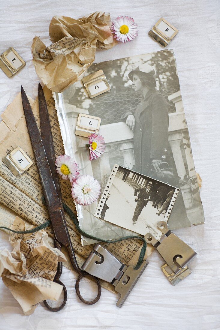 Vintage arrangement of daisies, vintage scissors, metal clips and old photos