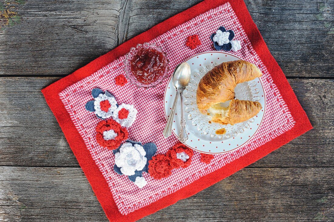 Frühstück auf rot-weißem DIY-Tischset mit Häkelblüten