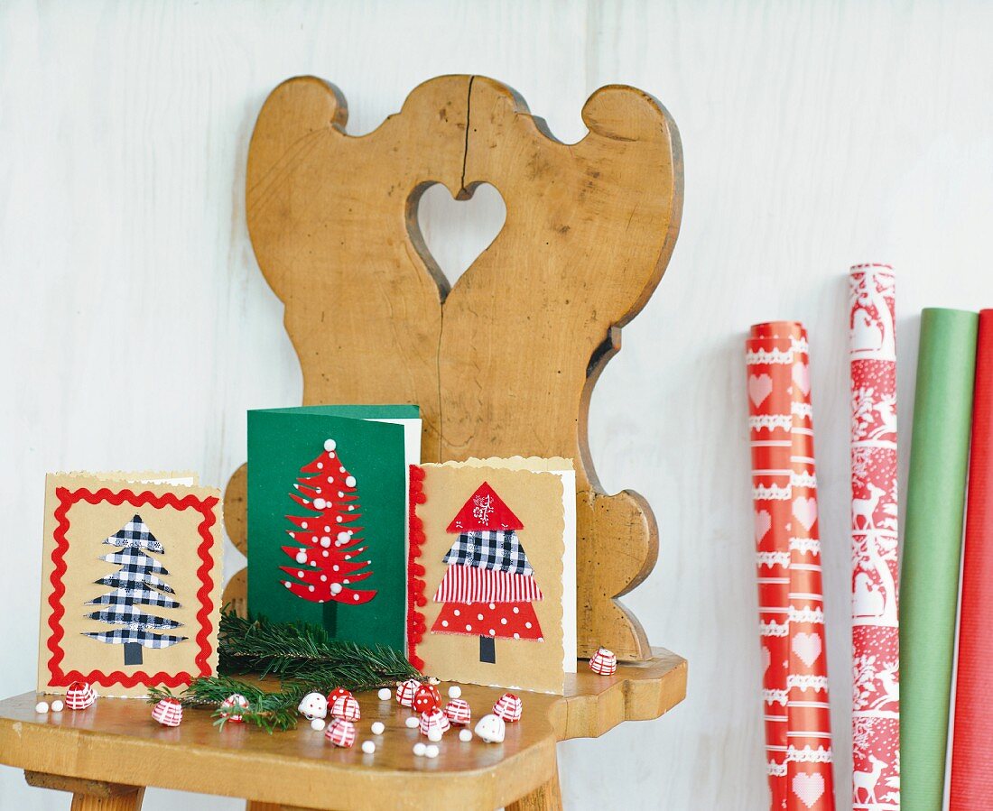 Selbstgebastelte Grußkarten mit Weihnachtsbäumen auf einem Bauernstuhl