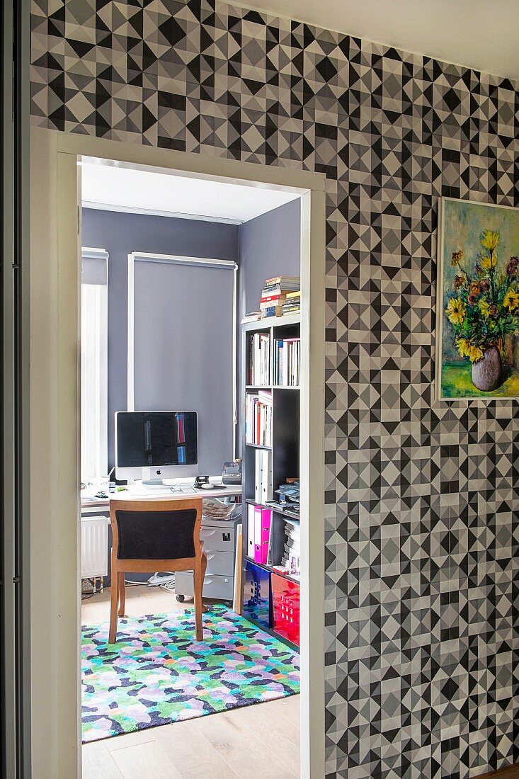 Wallpaper with graphic pattern in hallway and view into study through open door