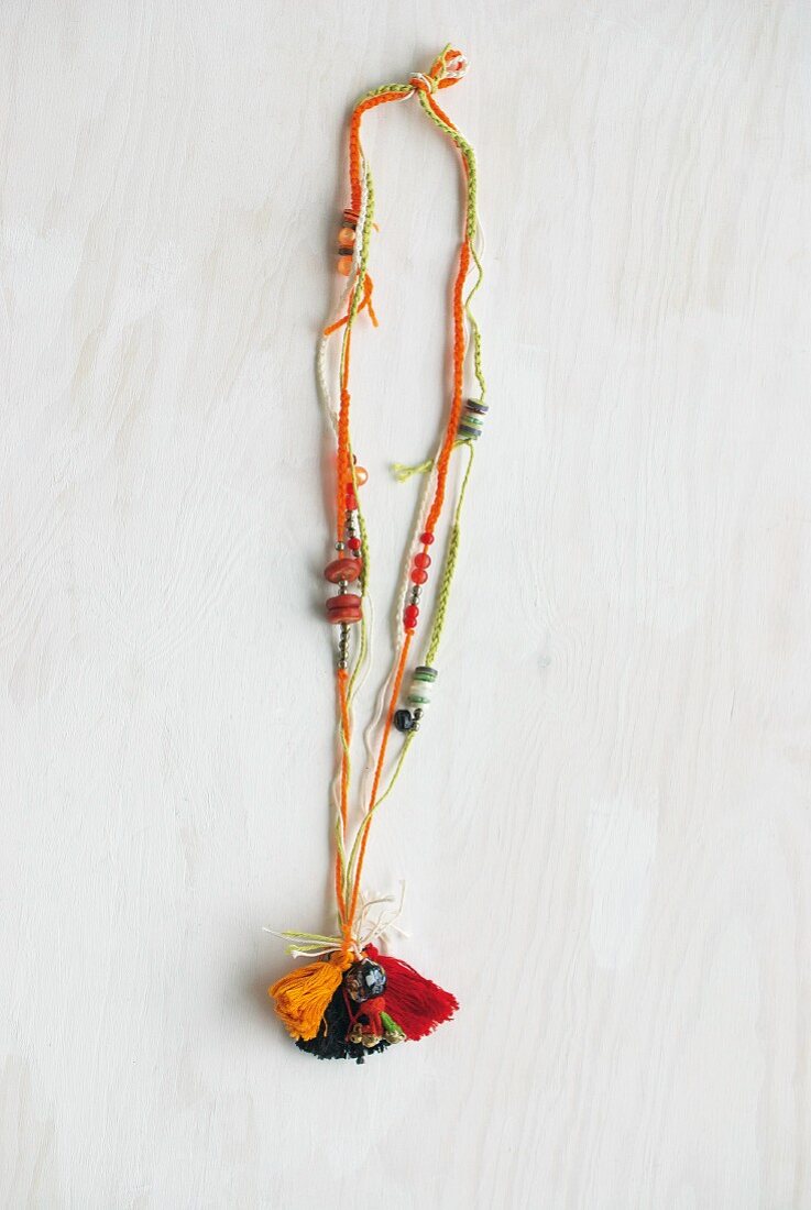 Necklace made from various crocheted cords, wooden beads and tassels