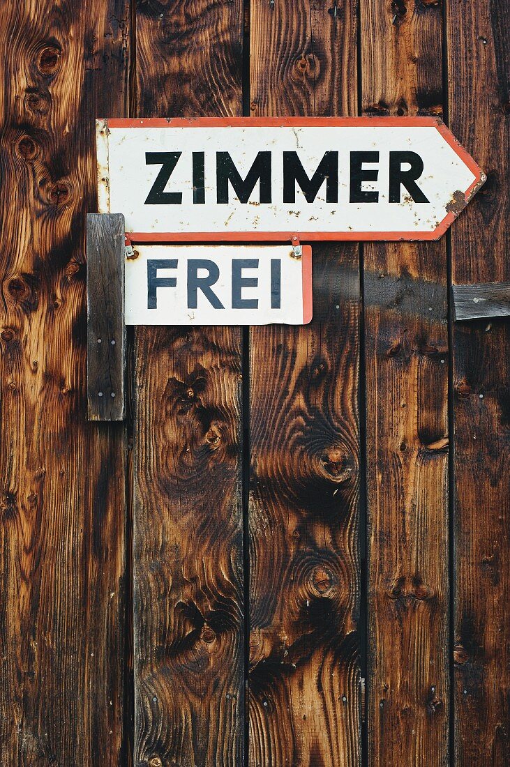 'Zimmer frei' (vacancy) sign on rustic board wall