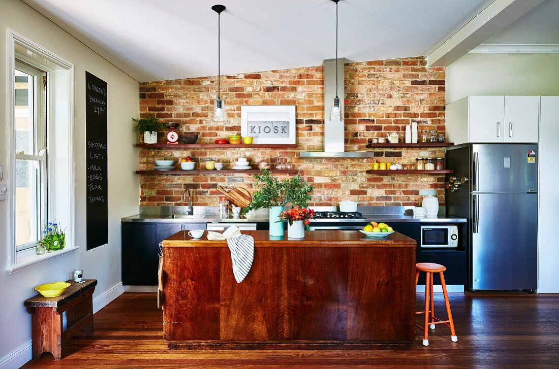 Kitchen with brick wall, kitchen island and wooden floor
