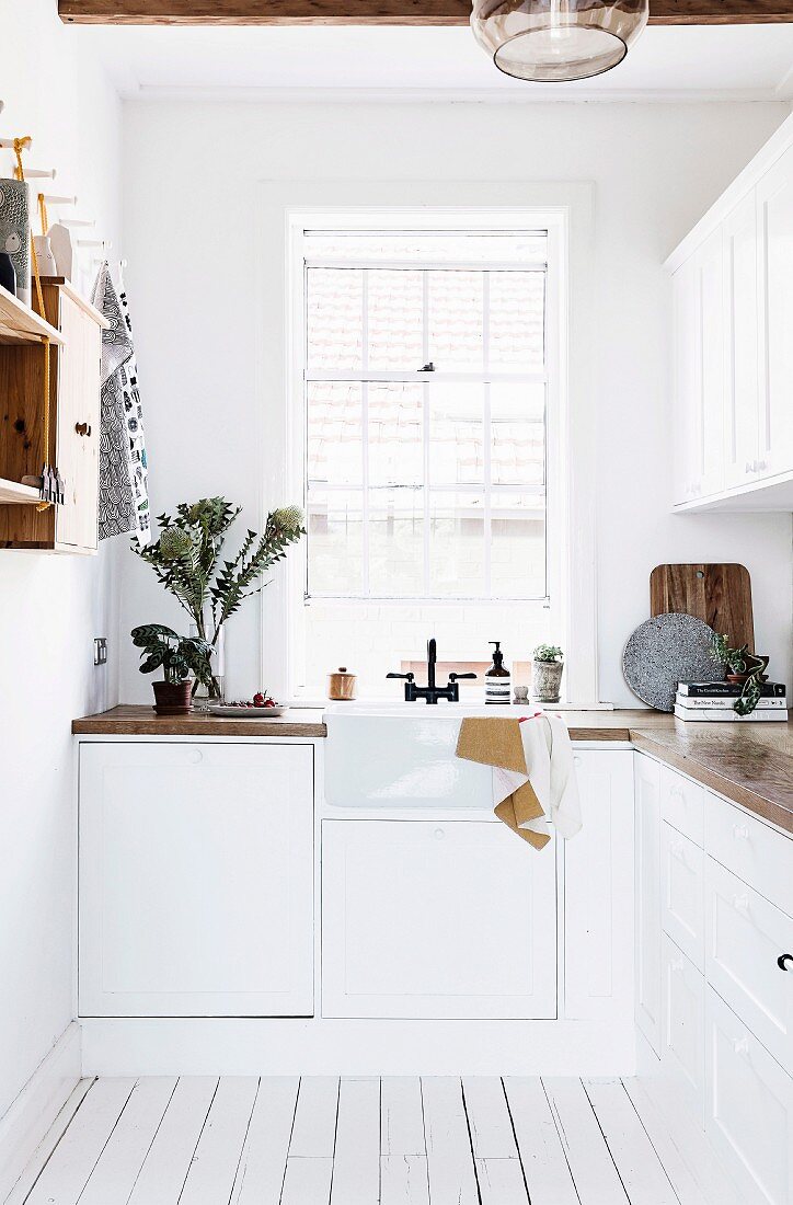 White country kitchen with sink in front of window