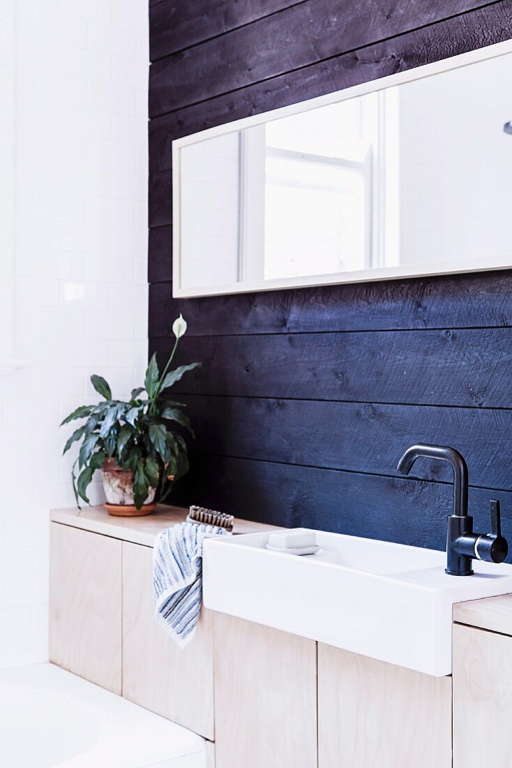 Waschtischzeile mit Holzunterschränken vor blauer Wandverschalung