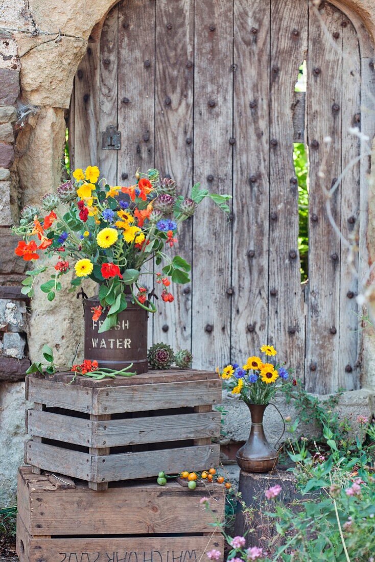Fresh flowers in pot on wooden crate