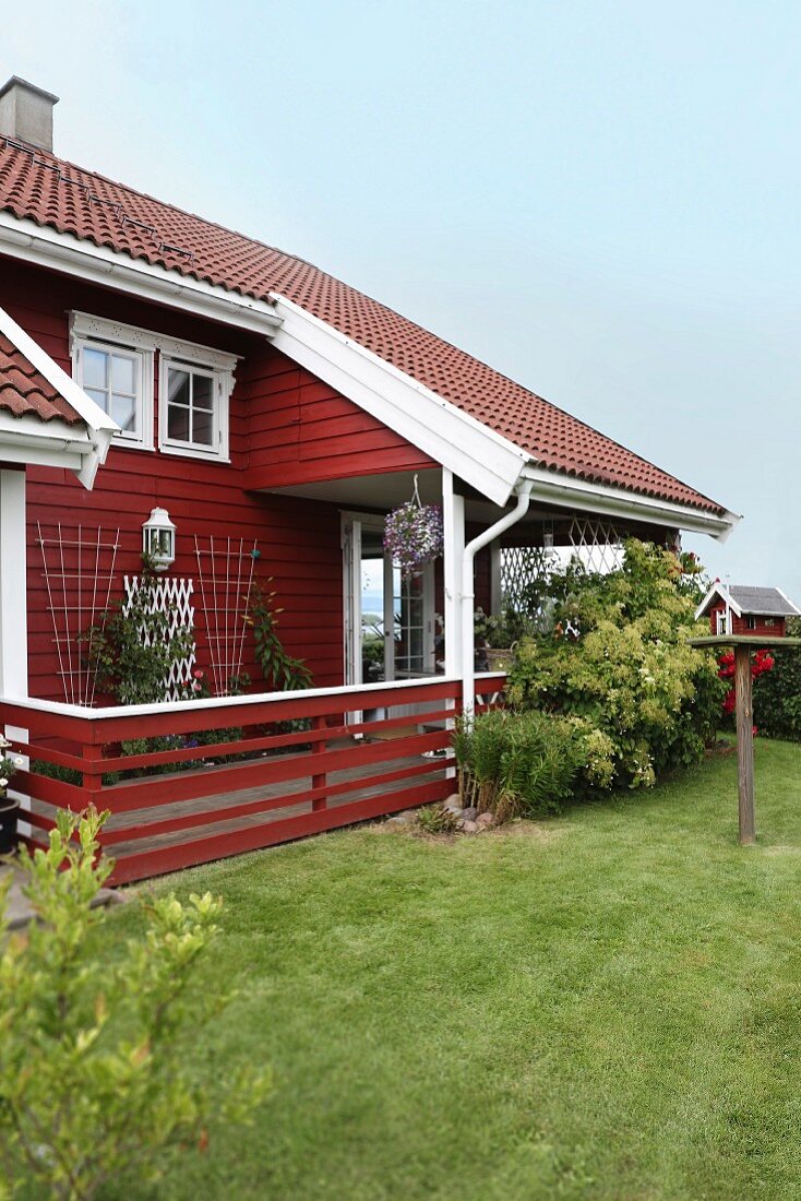 Rotes Holzhaus mit Veranda und Garten