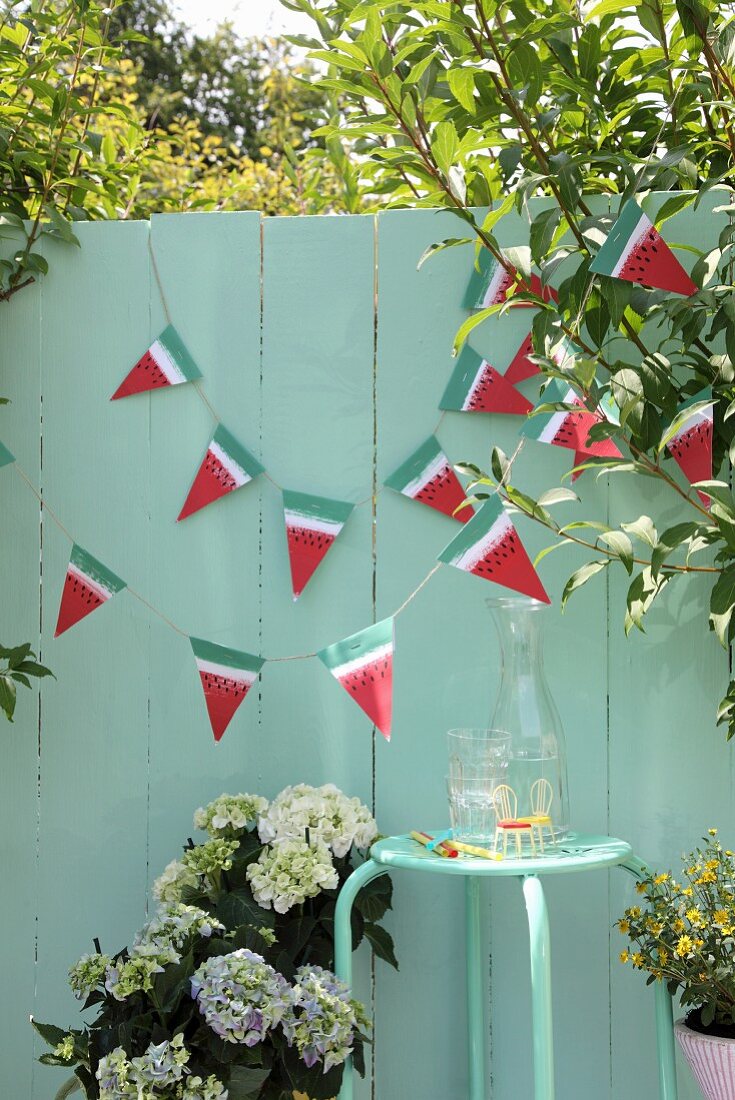 Hand-made bunting on green wooden fence in garden