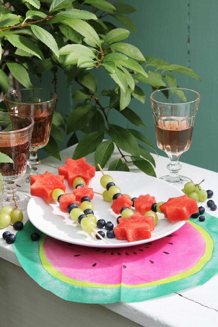 Fruit skewers on white plate and hand-made place mat