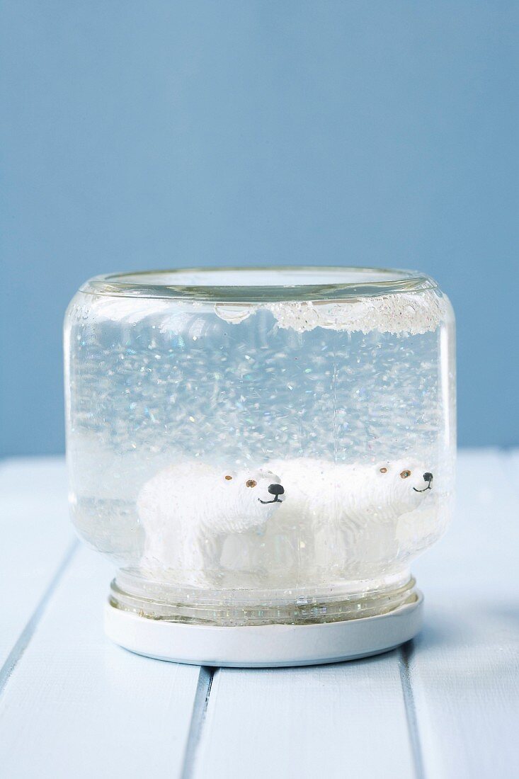 Two polar-bear figurines in snow globe hand made from screw-top jar