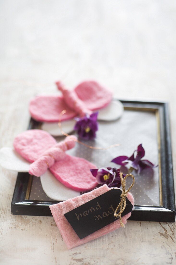 DIY Schildchen und Schmetterlinge aus rosa Filz auf schwarzem Vintage-Bilderrahmen