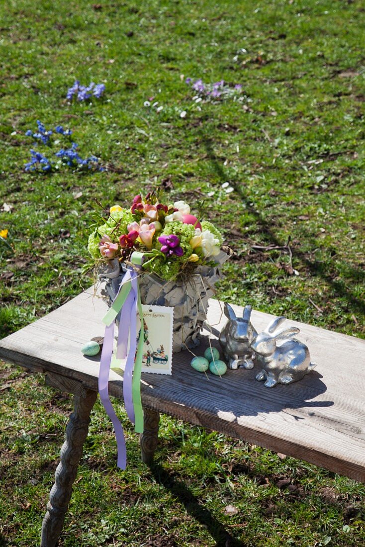 Blumen in einer mit Kartonstücken bekelbten Vase im Freien
