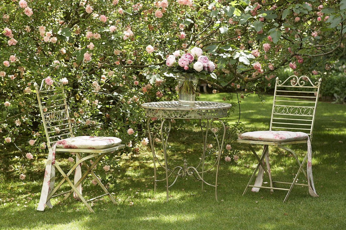 Romantischer Rückzugsort in blühendem Rosengarten