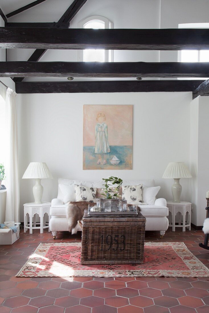 White sofa in lounge of renovated farmhouse with exposed beams