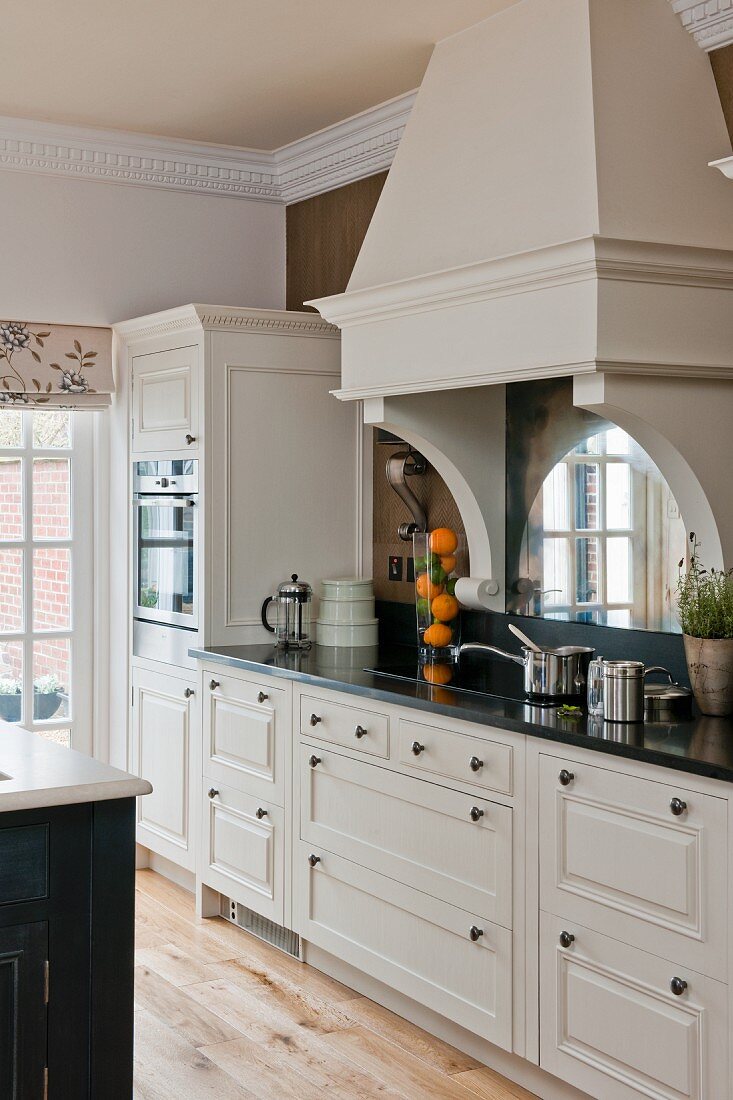 weiße Landhausküche mit nostalgischem Charme und schwarzer Silestone-Küchenarbeitsplatte