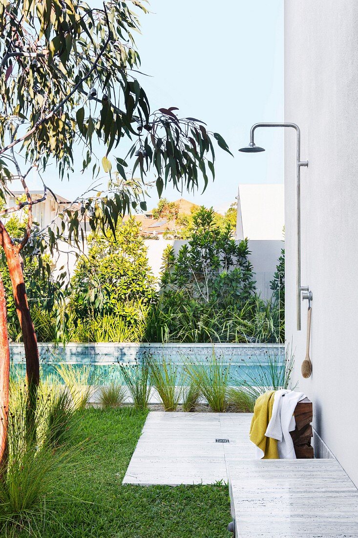 Simple outdoor shower on the house wall next to the pool