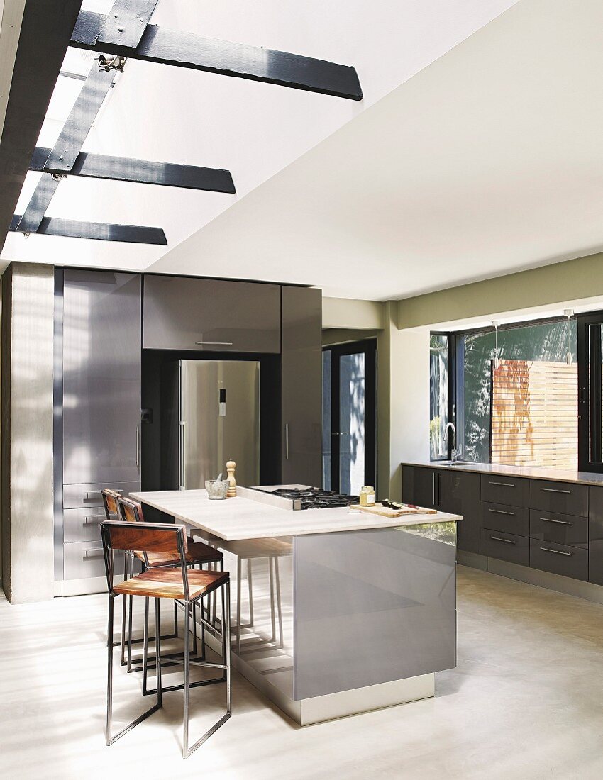 Free-standing counter in grey kitchen with light falling through skylight