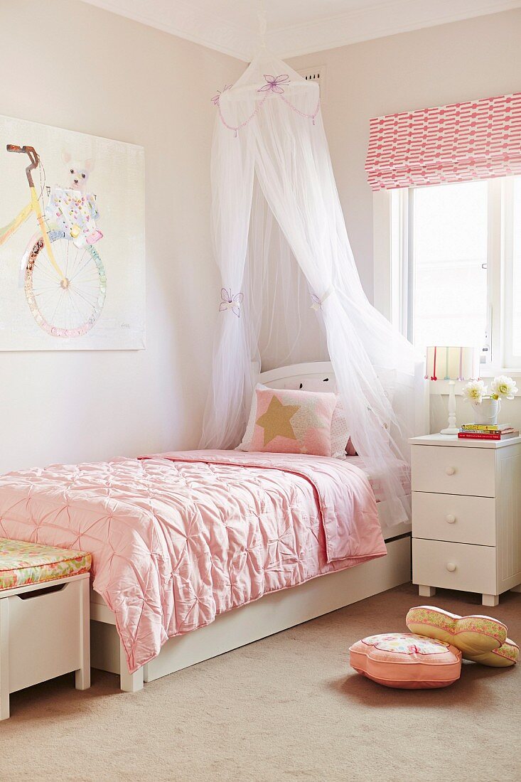 Romantic girl's room with canopy bed and pink duvet