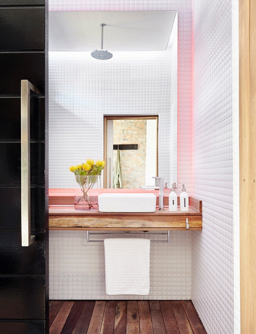Blick in kleines Badezimmer mit Mosaikfliesen und Holzboden