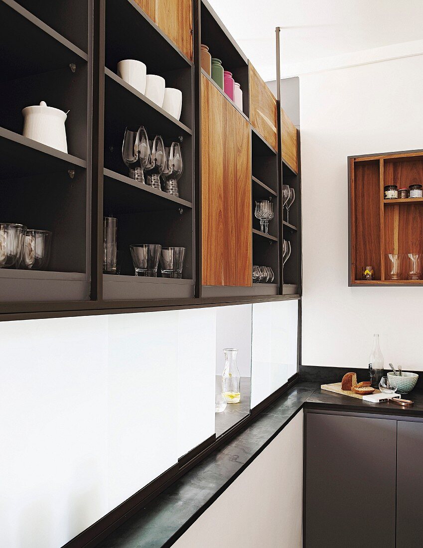 Crockery and glasses on elegant fitted shelves above serving hatch