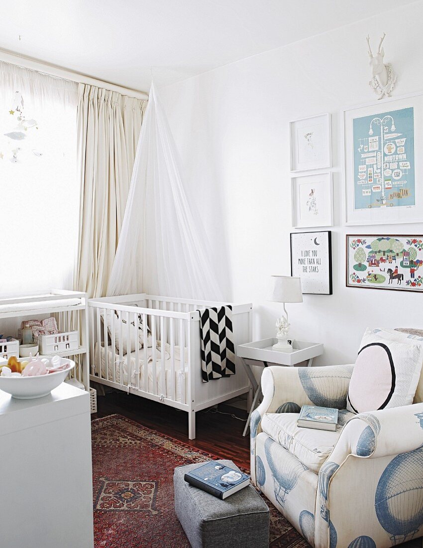 Kinderzimmer mit weißem Gitterbett und gemütlichem Lesesessel