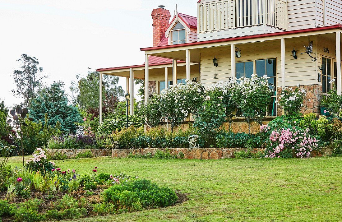 Haus mit umlaufender Veranda und Vorgarten