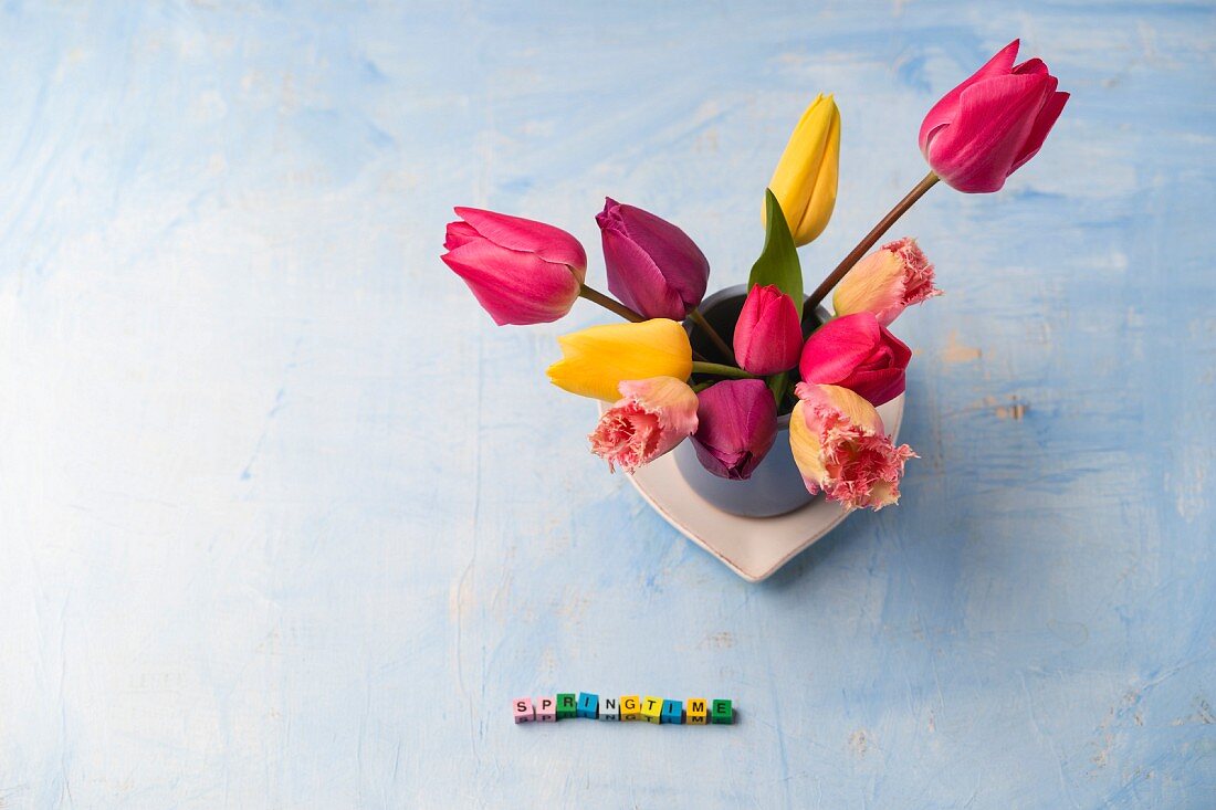 Frühlingsdeko: Tulpenstrauss und aus Würfeln gelegtes Wort Springtime