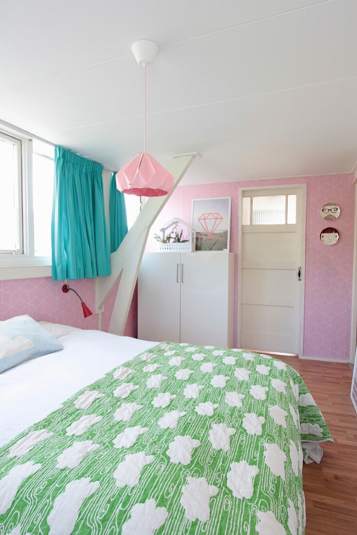 Schlafzimmer mit rosafarbener Tapete und türkisfarbenen Vorhängen im Dachgeschoss