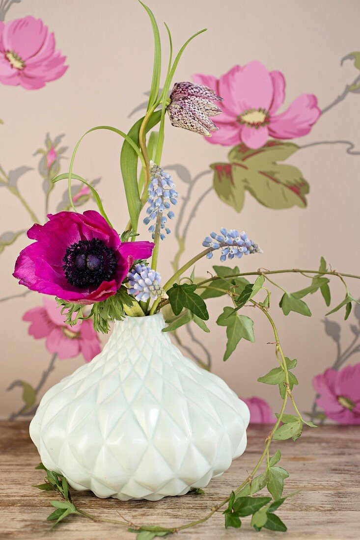 Violette Amemone, Schachbrettblume und Traubenhyazinthen in weisser Retro Vase
