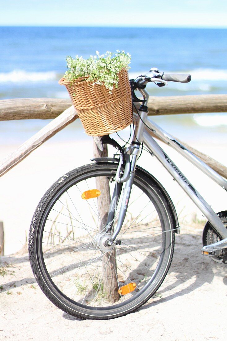 Fahrrad angelehnt an Holzgeländer am Strand