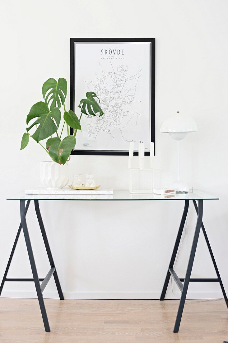 Grüne Zimmerpflanze, Kerzenhalter und Panton-Lampe auf filigranem Konsolentisch aus Böcken und Glasplatte