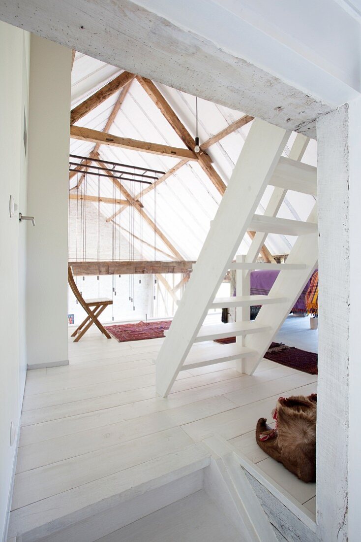 White ladder staircase on landing in converted barn
