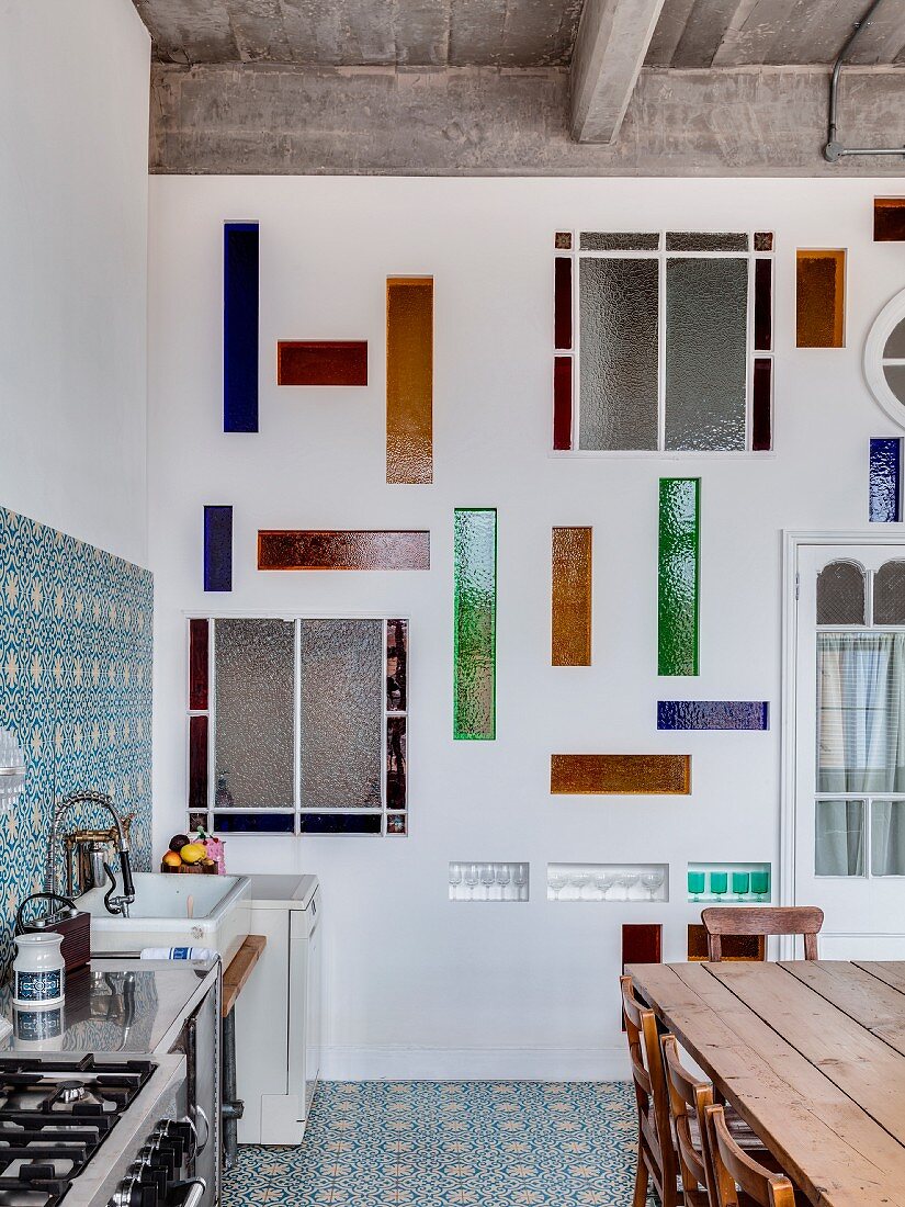 Wandgestaltung mit Buntglasscheiben in Küche einer Loftwohnung