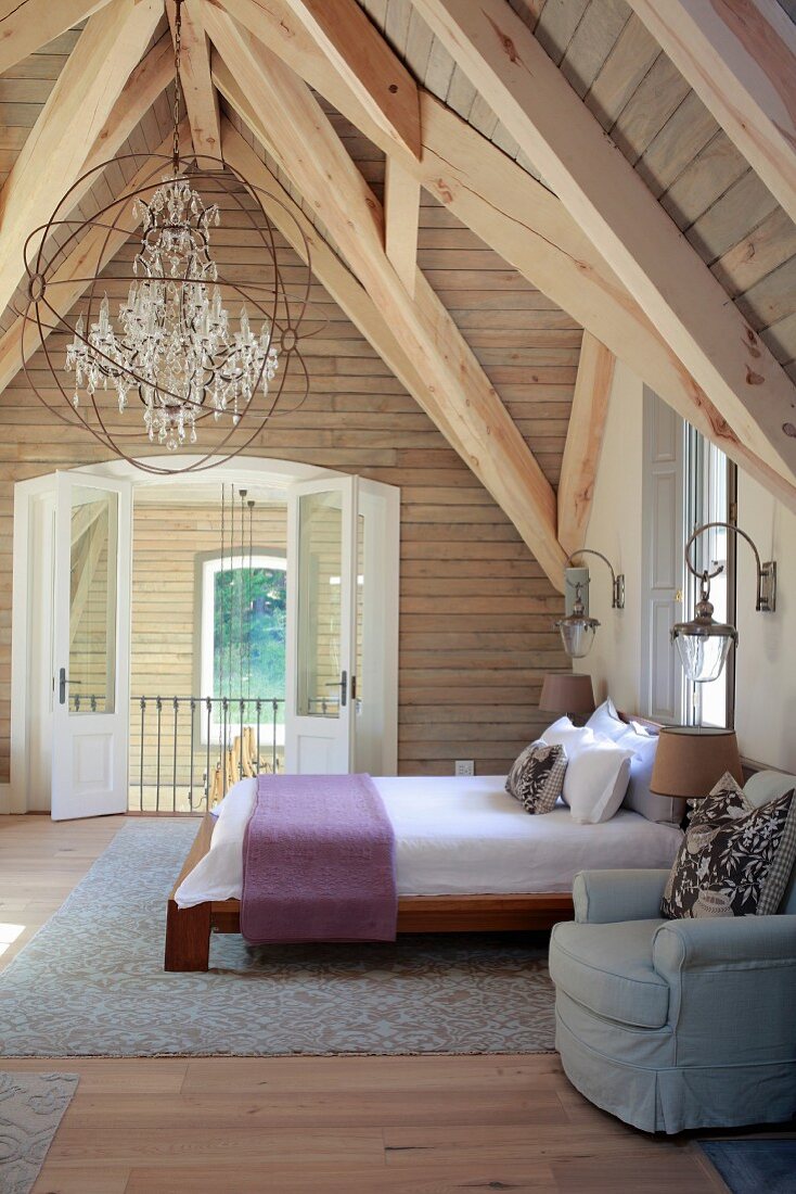Schlafzimmer in Dachgeschoss mit rustikaler Holzkonstruktion
