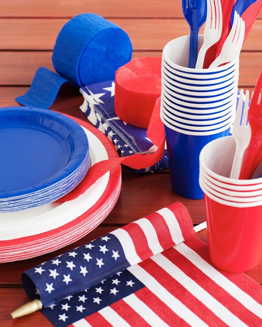 Paper plates, paper cups, plastic cutlery and streamers in red, white and blue for the fourth of July