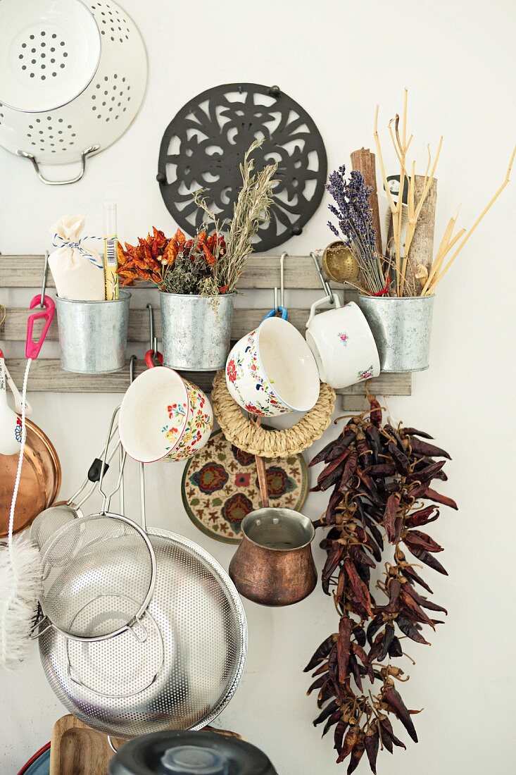 Various kitchen utensils and dried spices hung from vintage rack