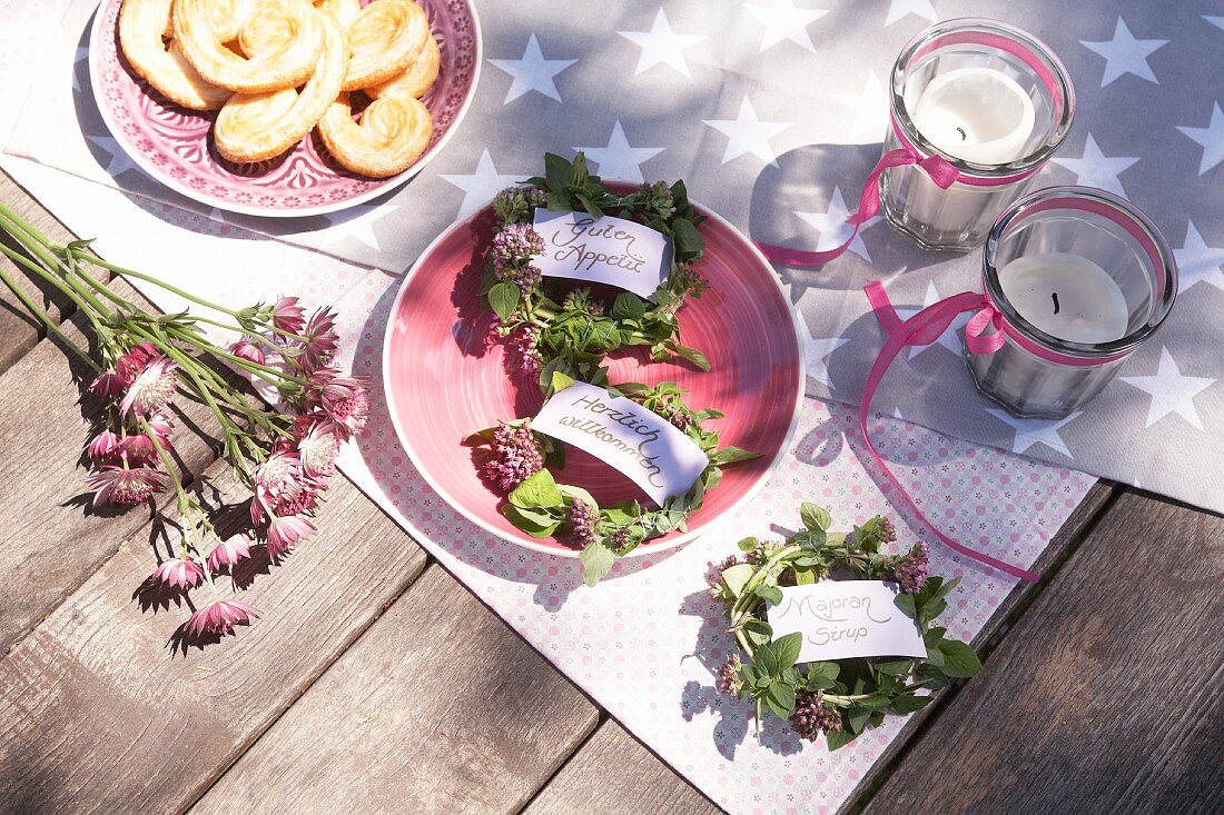 Tags on small wreaths of marjoram on picnic blanket