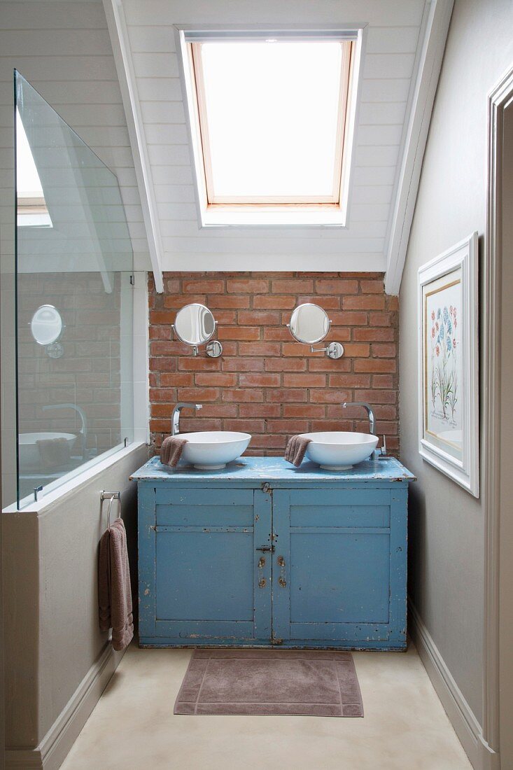 Battered blue washstand in niche under sloping ceiling