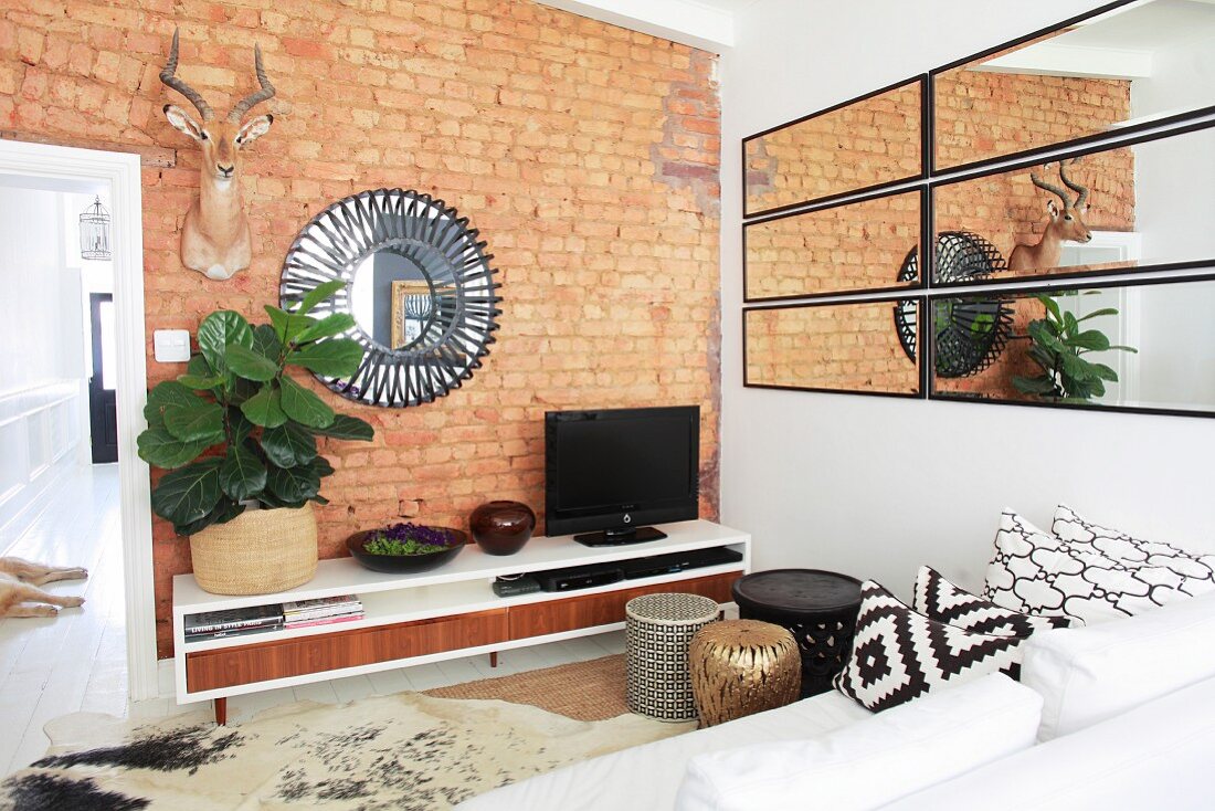 Brick wall and mirrors in ethnic living room