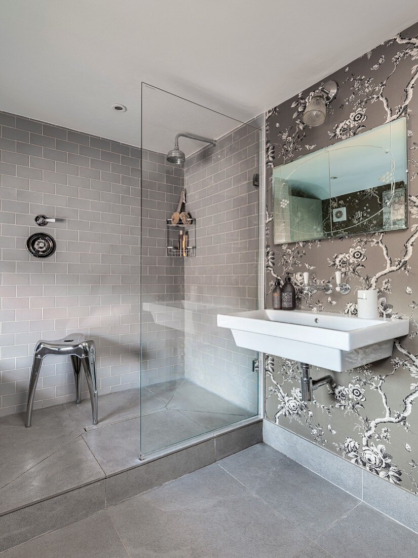 Shower area and floral wallpaper in elegant bathroom in shades of grey