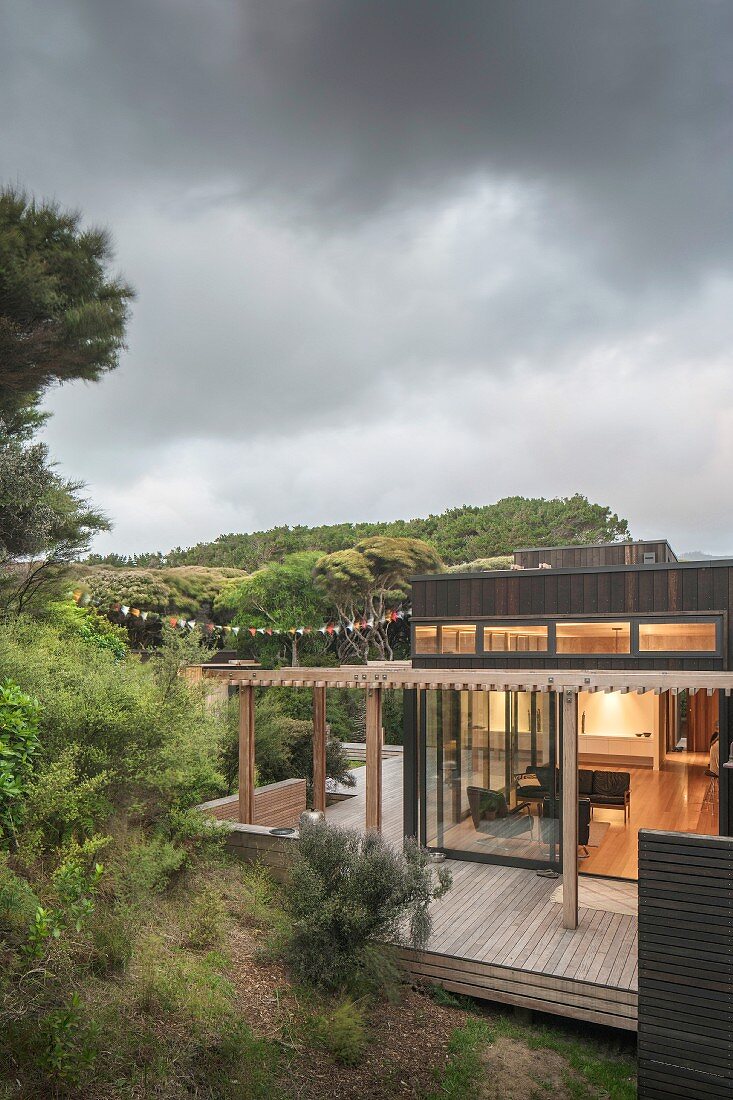 Gewitterstimmung über Holzhaus mit Terrasse